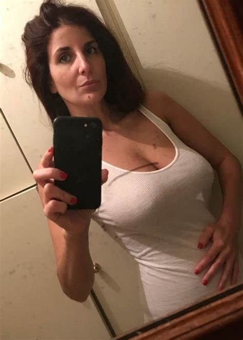 A Woman Taking A Selfie In Front Of A Bathroom Mirror With Her Cell Phone