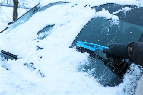 Premium Photo Removing Snow From Car Windshield Closeup