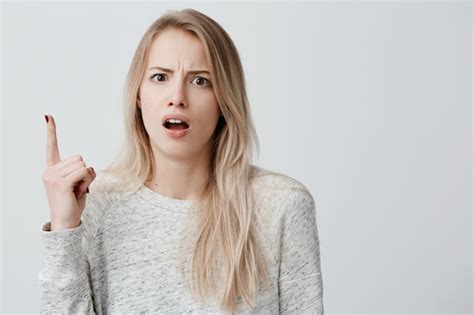 Free Photo Amazed Dissatisfied Woman With Dyed Blonde Hair Dressed Casually Pointing With Her