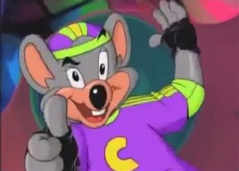 A Cartoon Mouse Wearing A Purple Shirt And Yellow Hat With His Hands In