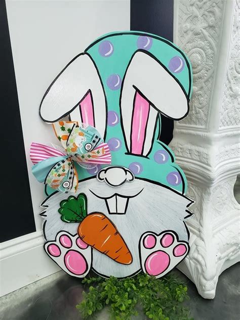 A Wooden Sign With A Rabbit Holding A Carrot