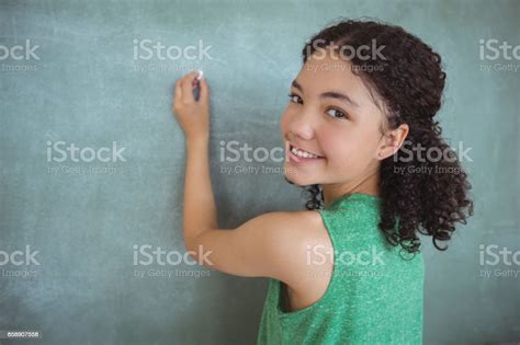 Portrait Of Schoolgirl Pretending To Be A Teacher In Classroom Stock