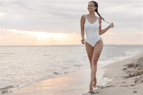 Mulher bonita em trajes de banho na praia Foto Grátis