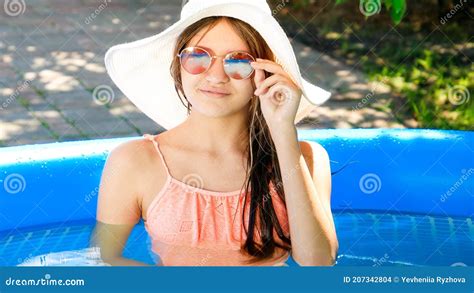 Beautiful Girl In Sunglasses And Hat Relaxing In Swimming Pool Stock