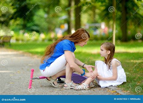 Mother Comforting Her Daughter After She Fell While Riding Her Scooter Stock Image Image Of