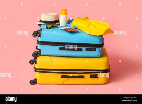 Suitcases Passports Tickets And Beach Accessories On Pink Background