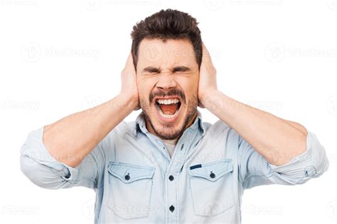 Emotional stress. Frustrated young man holding hands on ears and