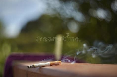 A forgotten cigarette lit. stock photo. Image of health - 235594978