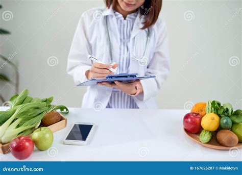 Portrait Of Young Smiling Female Nutritionist In The Consultation Room