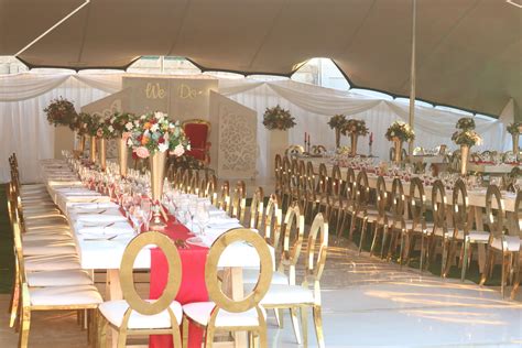 Traditional Wedding Decor With Gold Chairs And Red Tablecloths