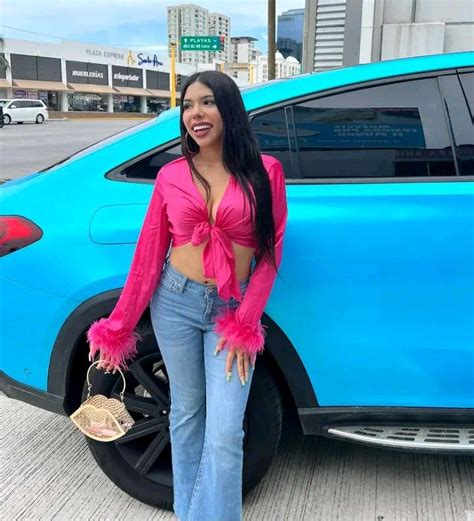 A Woman Standing Next To A Blue Car