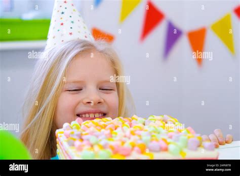 une fille blonde caucasienne qui s épluche derrière le gâteau d anniversaire avec un visage
