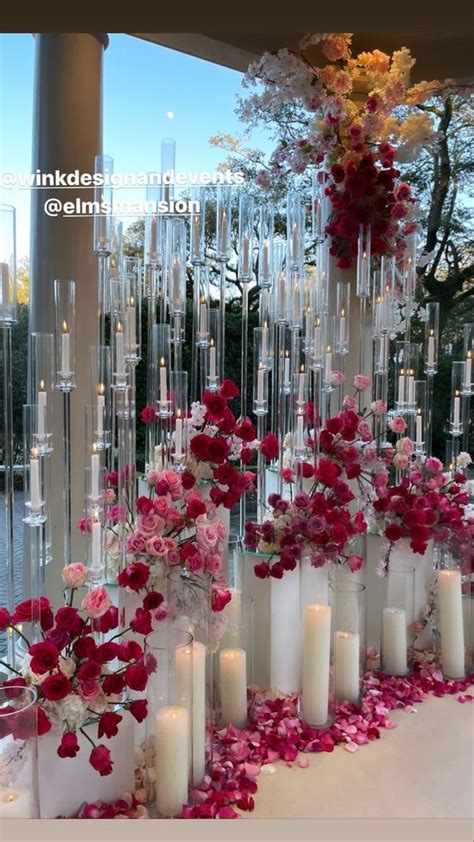 Many Tall Vases Filled With Flowers And Candles