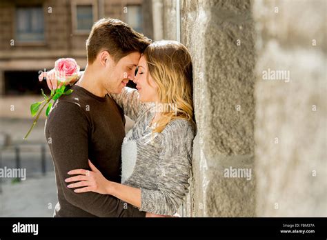 Candid Portrait Of Beautiful European Couple With Rose In Love Kissing