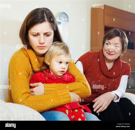 Jeune mère triste avec bébé et grand mère mature après querelle à la maison Photo Stock Alamy