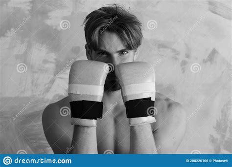 Guy With Naked Torso Wears Golden Boxing Gloves In Defending Position