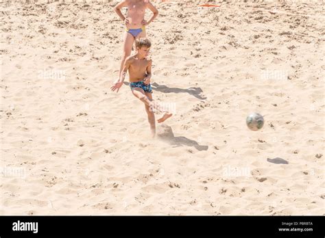 Boys teenagers playing soccer on the beach Stock Photo - Alamy