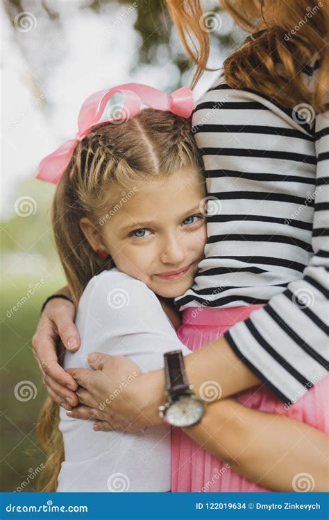 Blonde Haired Blue Eyed Appealing Daughter Hugging Her Parent Stock