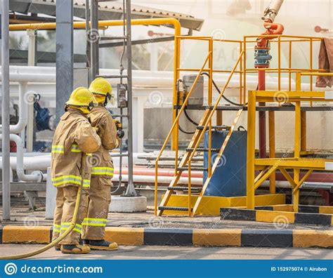 Firemans In Yellow Fire Fighter Uniform Holding Fire Hose Nozzle