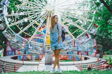 Belle Jeune Fille Blonde En Denim Dans L ensemble Avec Un Sac à Dos Posant Dans Un Parc D