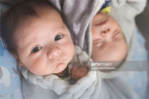Newborn Male Fraternal Twins Are Next To Each Other On The Couch In