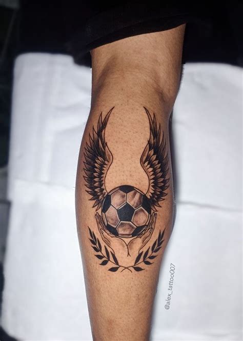 A Man With A Tattoo On His Leg That Has A Soccer Ball And Wings Around It