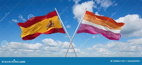 Two Crossed Flags Lesbian Pride And Spain Waving In Wind At Cloudy Sky