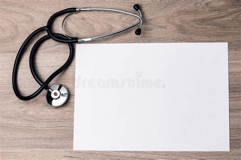 A Medical Stethoscope And A White Sheet Of Paper Lie On The Textured