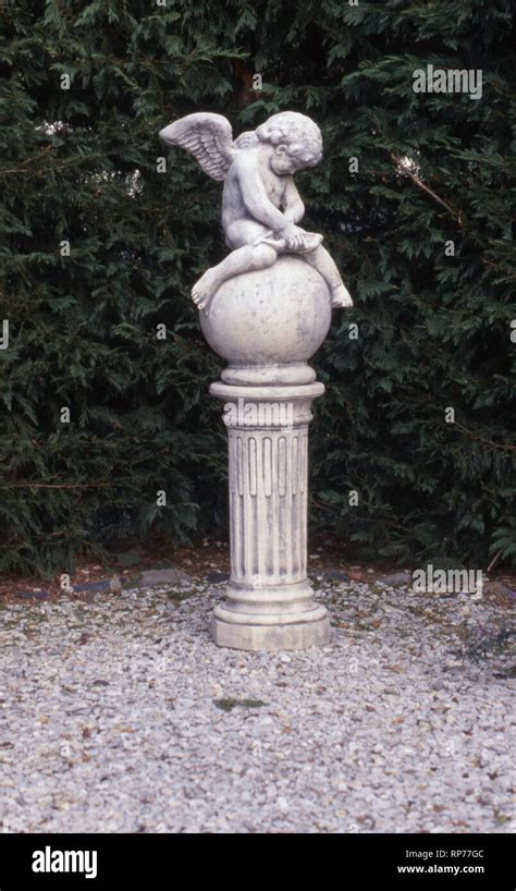 Garden Statue Of A Cherub Winged Angel Sitting On Large Stone Ball Holding A Small Harp New