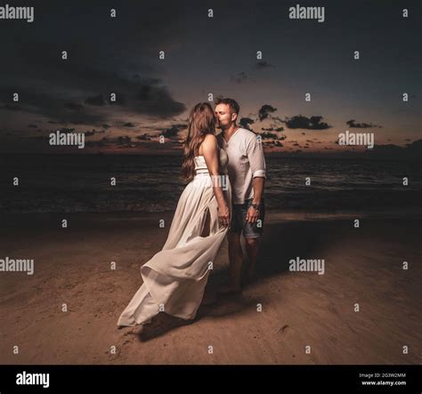 Romantic couple on th beach during sunset Stock Photo - Alamy