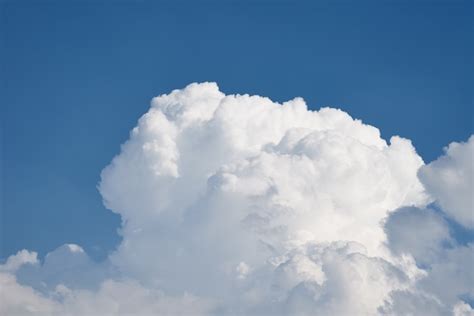 Nahaufnahme einer großen weißen flauschigen Wolke am klaren blauen