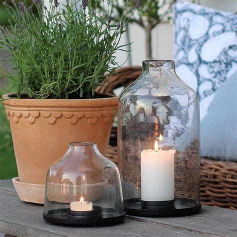 Two Glass Vases Sitting On Top Of A Wooden Table Next To A Potted Plant