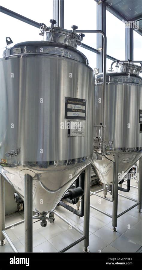 Row Of Shiny Metal Micro Brewery Tanks Or Fermentation Mash Vats In