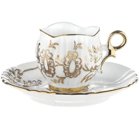 An Ornate Tea Cup And Saucer With Gold Trimmings