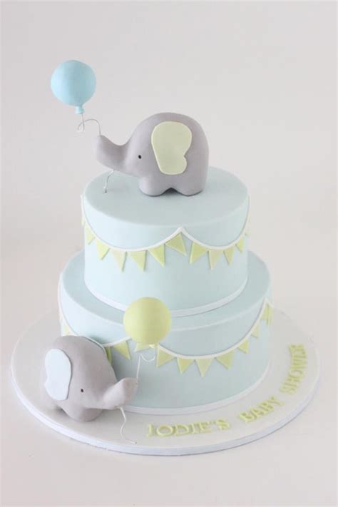 A Cake With An Elephant On Top And Balloons In The Shape Of Two