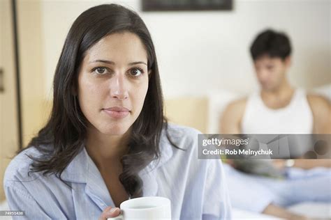 Women Holding Coffee Mug Sitting On End Of Bed Portrait High Res Stock