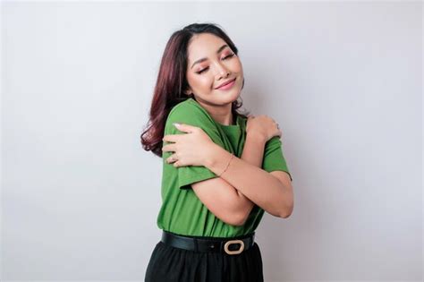 Joven hermosa mujer asiática con camiseta verde casual sobre fondo