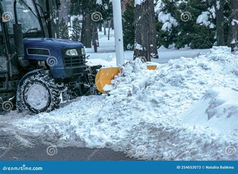 Blue Tractor Cleans City Streets And Roads After Heavy Snowfall