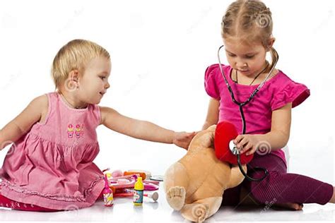 Children Playing Doctor With A Doll Stock Photo Image Of Cute