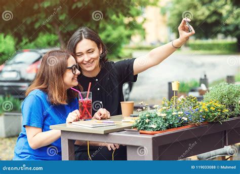 Deux Filles De Sourire Prenant Le Selfie Sur Le Smartphone Se Reposant