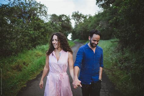 Couple Walking Together Outside In Green Lush Nature By Stocksy