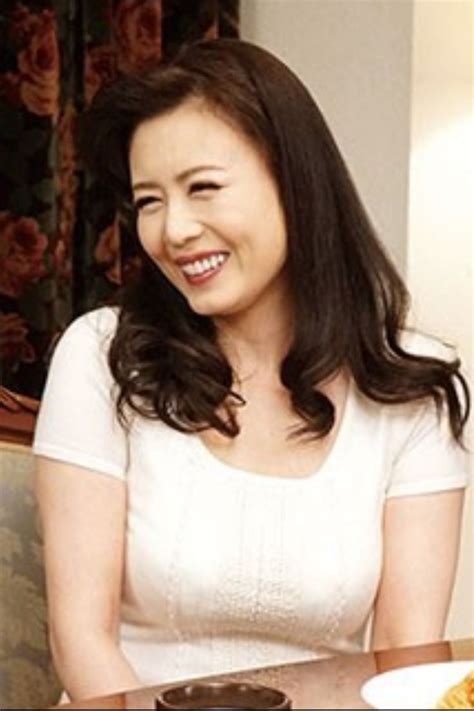 A Woman Sitting At A Table With Food In Front Of Her And Smiling For