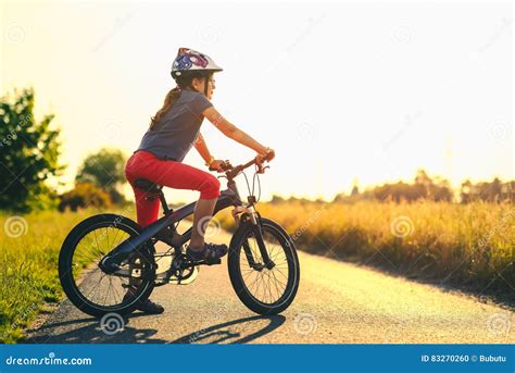 Silhouette De Jeune Fille Sur Une Bicyclette Au Coucher Du Soleil Photo