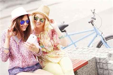 Premium Photo Girl Friends Riding A Tandem Bicycle And Taking Selfie