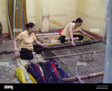 Two Vietnamese Ladies Sitting On The Floor Of Silk Sales Shop Weaving A