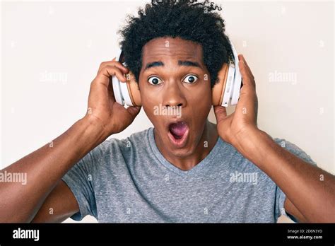 Handsome African American Man With Afro Hair Listening To Music Using