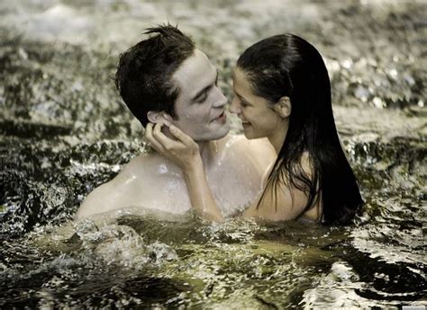 A Man And Woman Are In The Water With Their Heads Close To Each Other