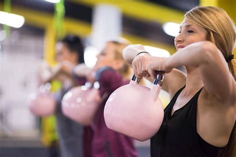 Grupo de atletas jóvenes sanos que hacen ejercicios con kettlebells en