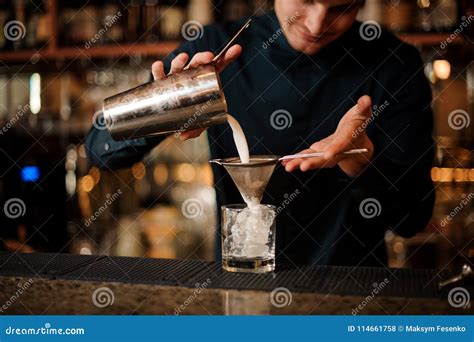 Bartender Pouring An Alcoholic Cocktail Into A Cocktail Glass From A