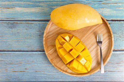 Yellow Half Mango With Small Fork Mango Fruit Cubes On The Blue Wooden